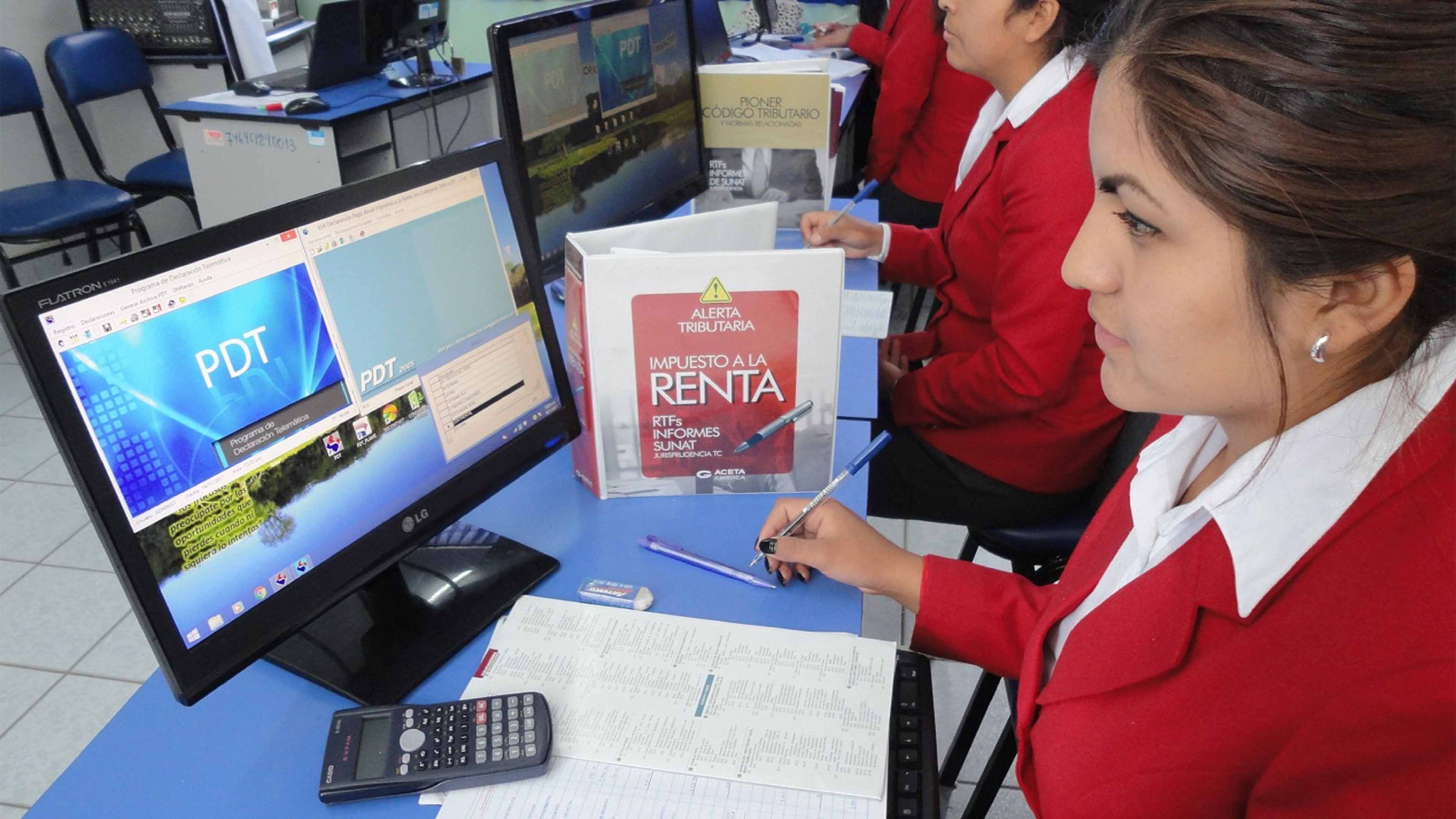 Imagen de una estudiante en una PC y libros contables en representación de la carrera de contabilidad
