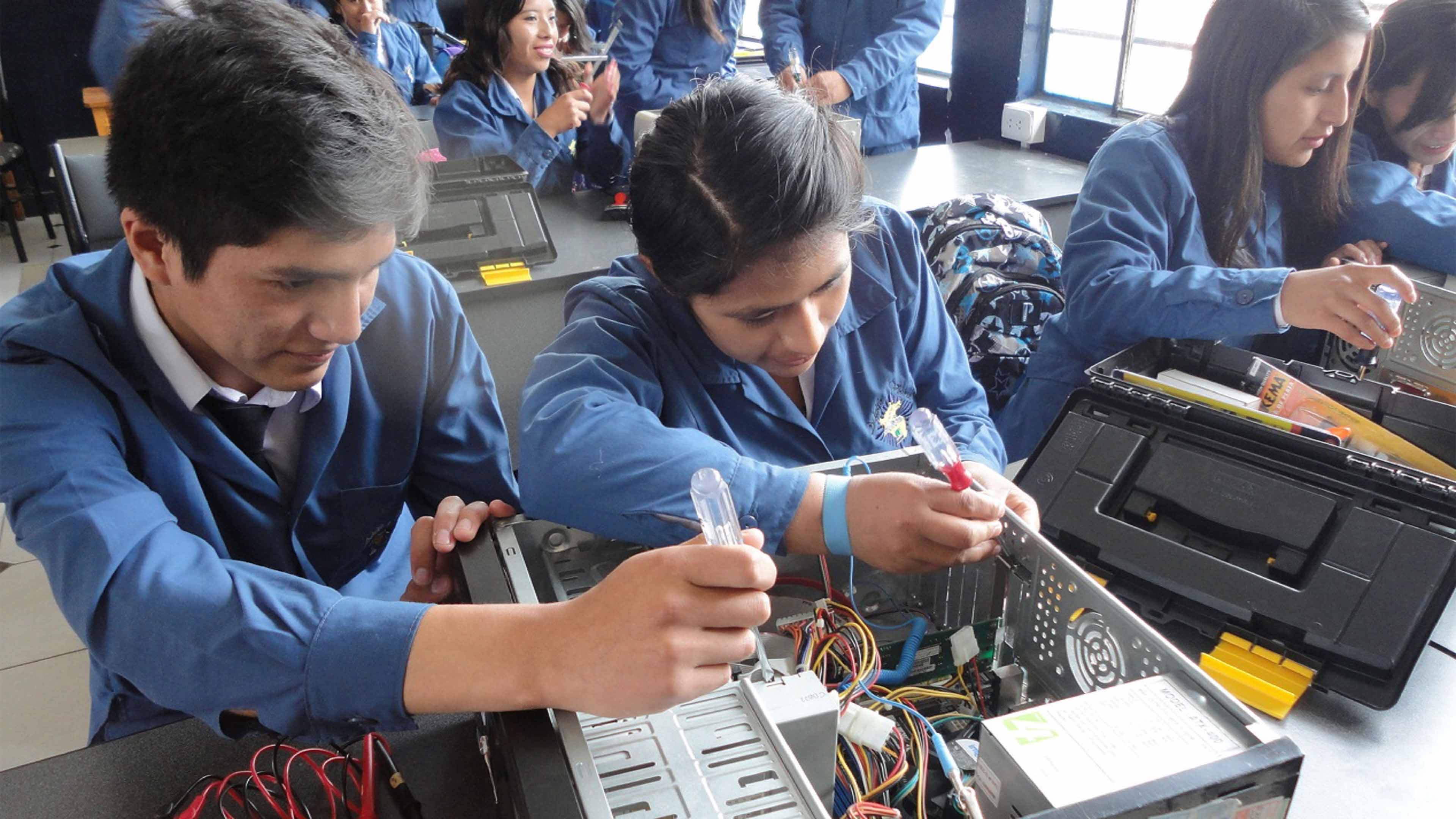 Imagen de dos estudiantes con una PC abierta en representación de la carrera de desarrollo de sistemas de información