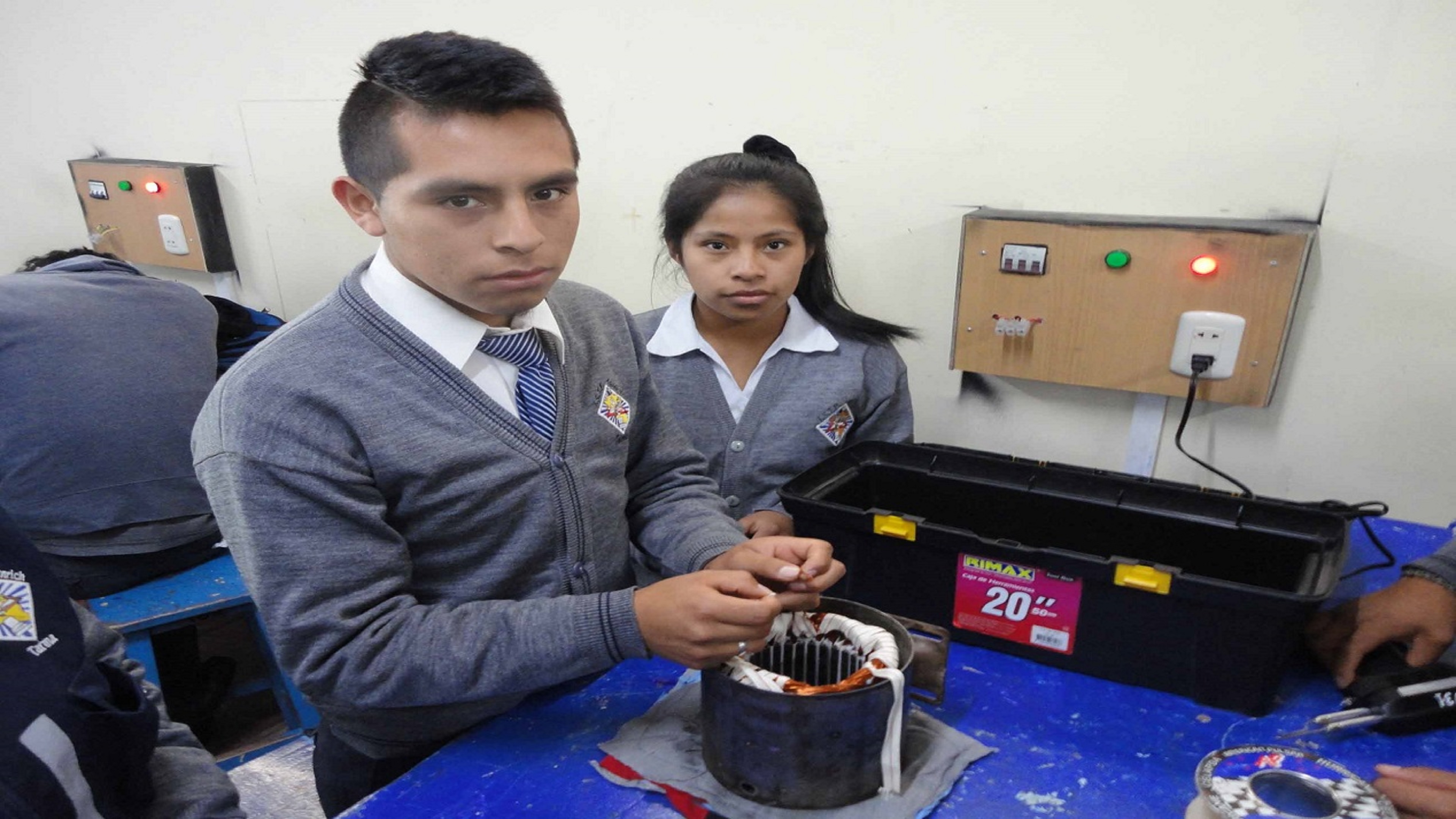 Imagen de dos estudiantes con una máquina en representación de la carrera de arquitectura y servicios de tecnología de la información