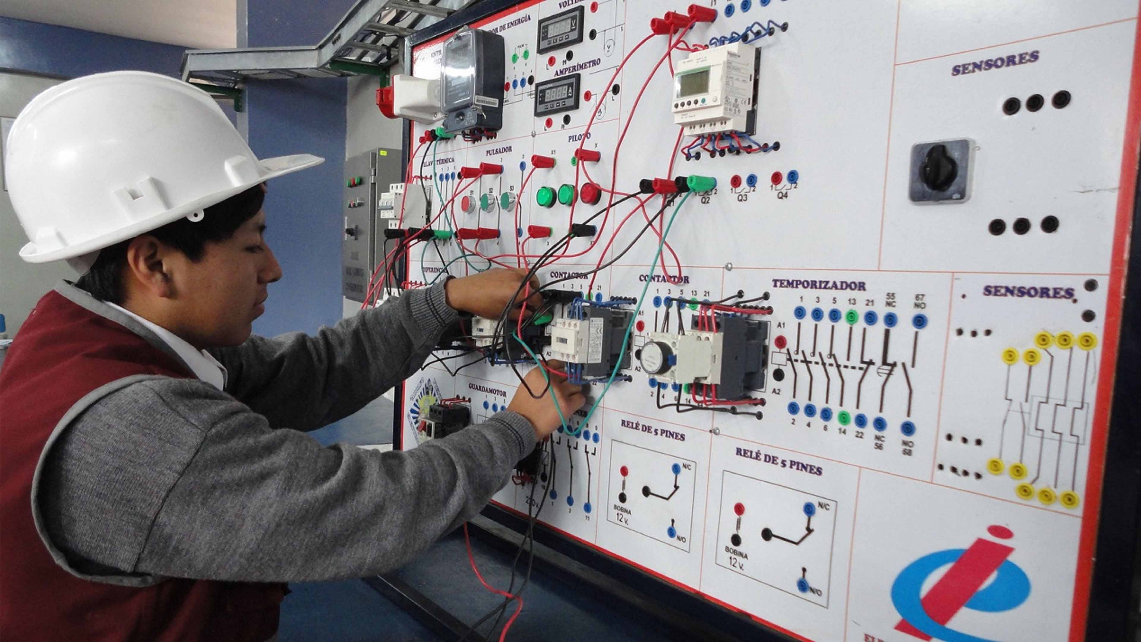 Imagen de un alumno con un panel de control eléctrico en representación de la carrera de electrónica industrial